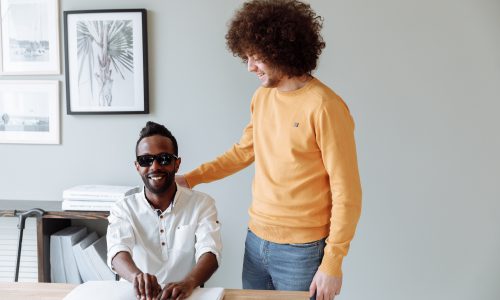 man helping other man to read